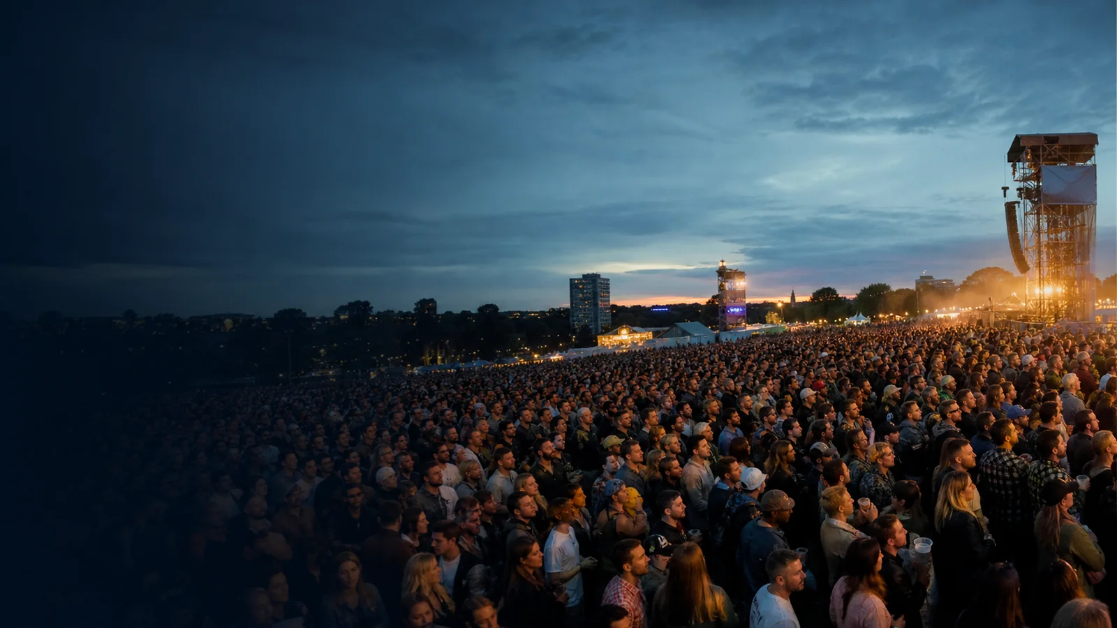 A large, orderly outdoor event crowd at dusk